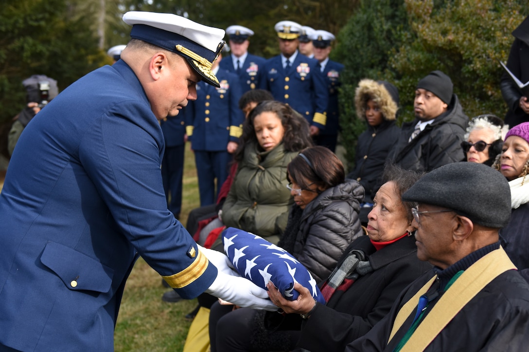 Rear Adm. Andrew Tiongson, commander First Coast Guard District, passes a folded American flag to a family member during funeral services for Dr. Olivia Hooker in White Plains, New York, Dec. 5, 2018.