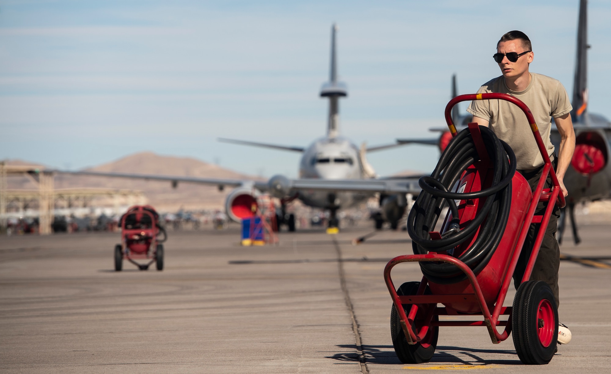 U.S. Air Force Senior Airman Dylan Sherrill, 20th Aircraft Maintenance Squadron, 79th Aircraft Maintenance Unit (AMU) crew chief, moves a flightline fire extinguisher during Exercise Red Flag 19-1 at Nellis Air Force Base, Nev., Jan. 28, 2019.