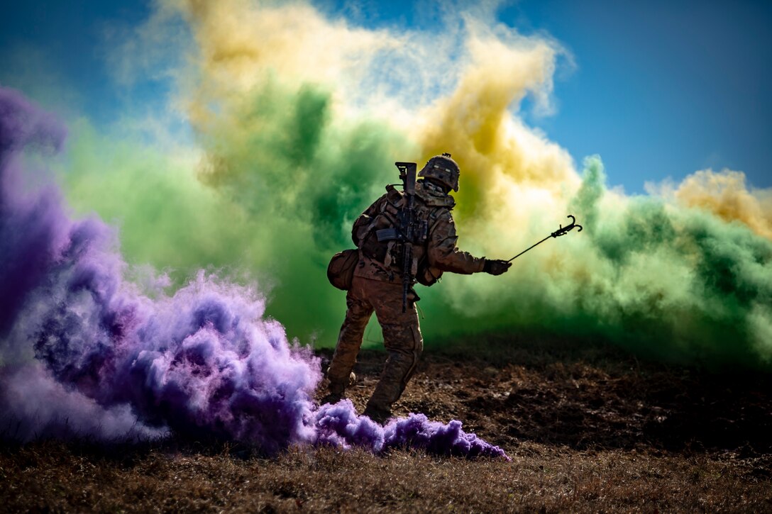 A soldier stands surrounded by smoke.