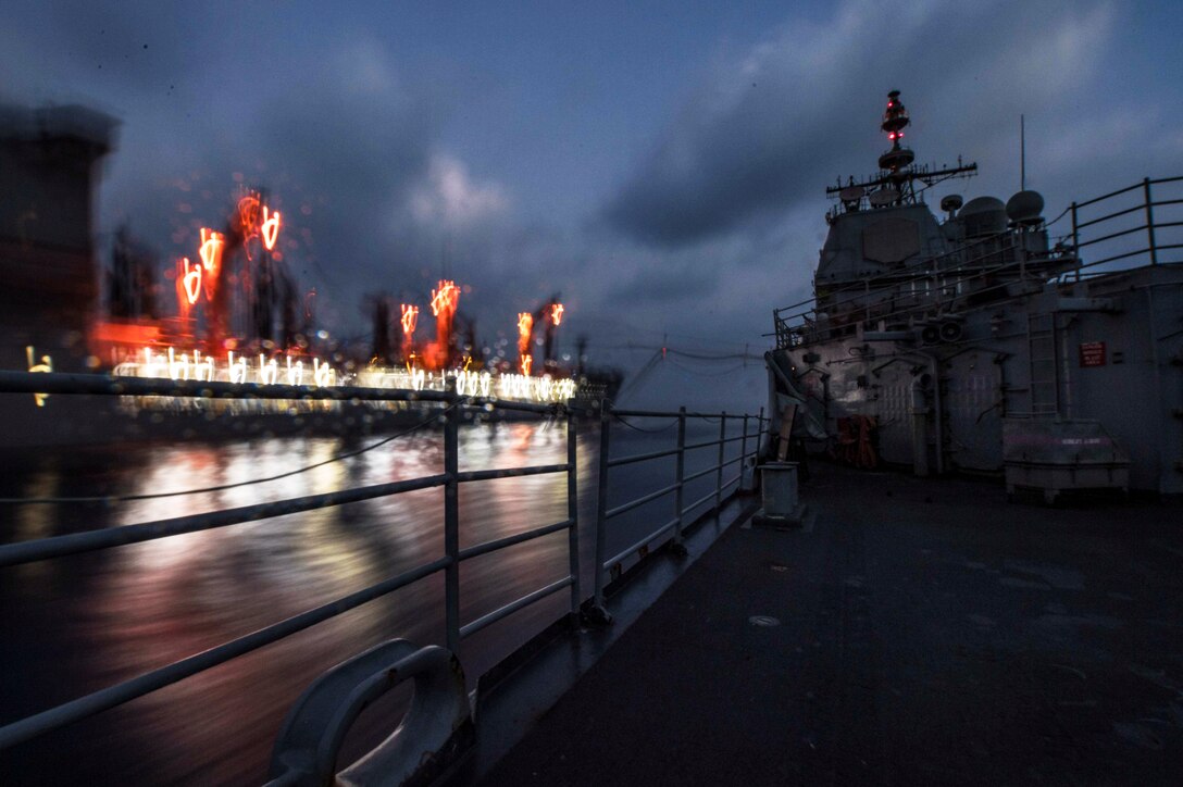 Two ships travel next to each other in the ocean.