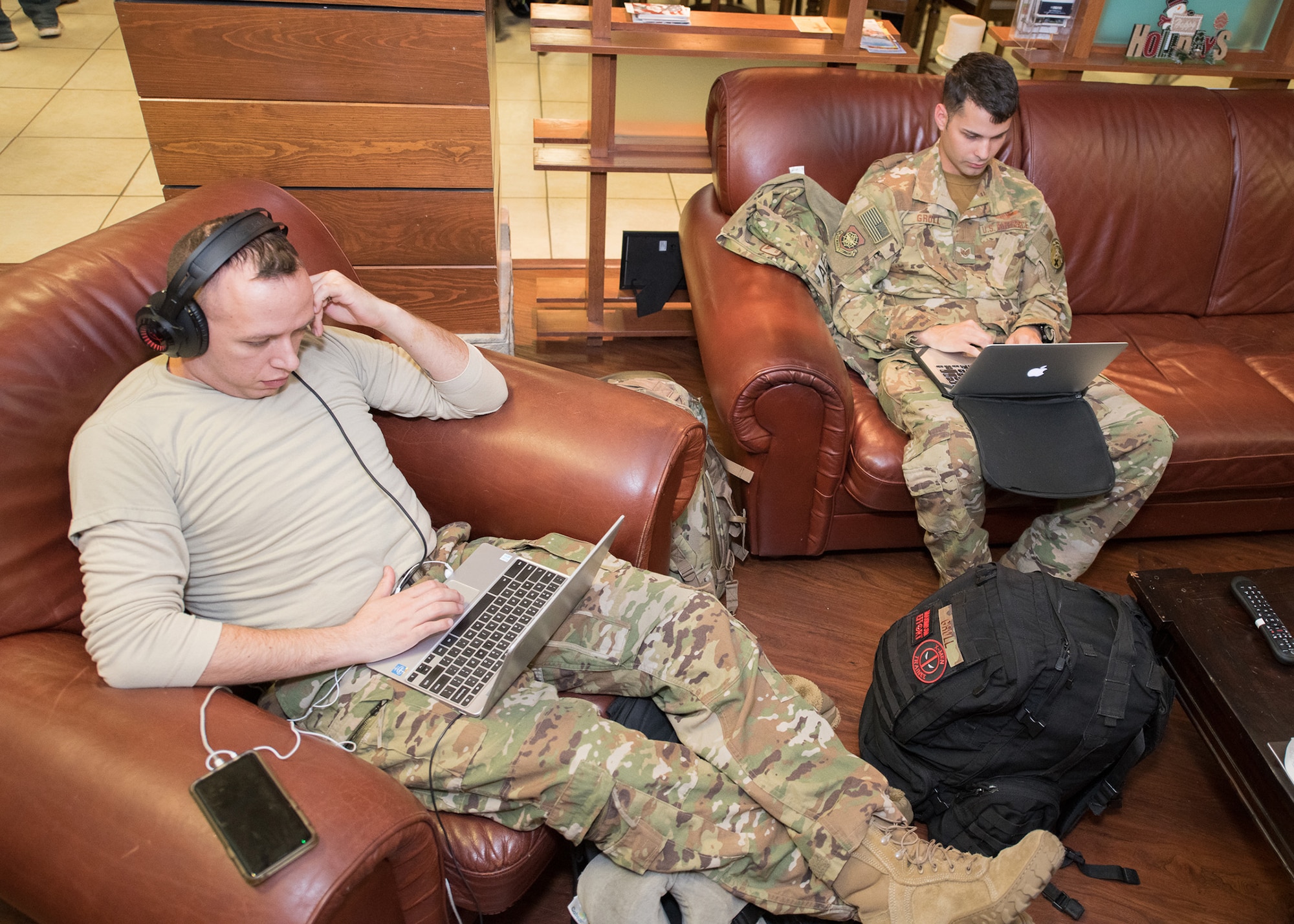 From left, Staff Sgts. Carlos Marles and Brian Groll, both aeromedical evacuation technicians assigned to the 375th Aeromedical Evacuation Squadron and 10th Expeditionary Aeromedical Evacuation Flight, respectively, relax at the USO Delaware Terminal Community Center as they wait Jan. 18, 2019, at Dover Air Force Base, Delaware, for a flight to Europe. The USO center offers drinks, snacks and entertainment, as well as cellphone charging stations and an internet café with free Wi-Fi for traveling retirees, service members and their families. (U.S. Air Force photo by Mauricio Campino)