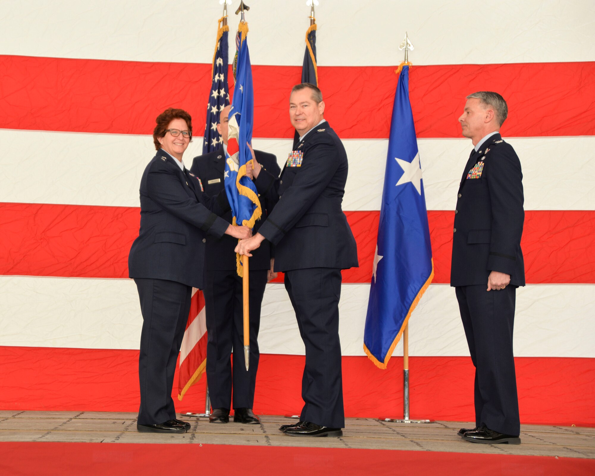 (Center) Col. Christopher McGraw, 136th Airlift Wing incoming commander, assumes command of the wing from Maj. Gen. Dawn Ferrell, Texas Air National Guard commander, during a change of command ceremony here January 26, 2019. McGraw comes to the wing after serving as director of operations, where he was responsible to the TANG commander on all matters pertaining to the direct operational planning, training, deployment and employment of more than 3,000 Airmen in three flying wings and five geographically separated units.
