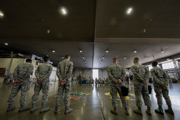 The fourth quarter load competition teams stand at ease prior to the event at Misawa Air Base, Japan, Jan. 18, 2019. The Airmen raced against the clock to gauge which team could accurately and efficiently load inert munitions onto an F-16 Fighting Falcon. It’s important for Airmen to practice this skill in order to be prepared if a real world scenario was to occur. (U.S. Air Force photo by Airman 1st Class Collette Brooks)