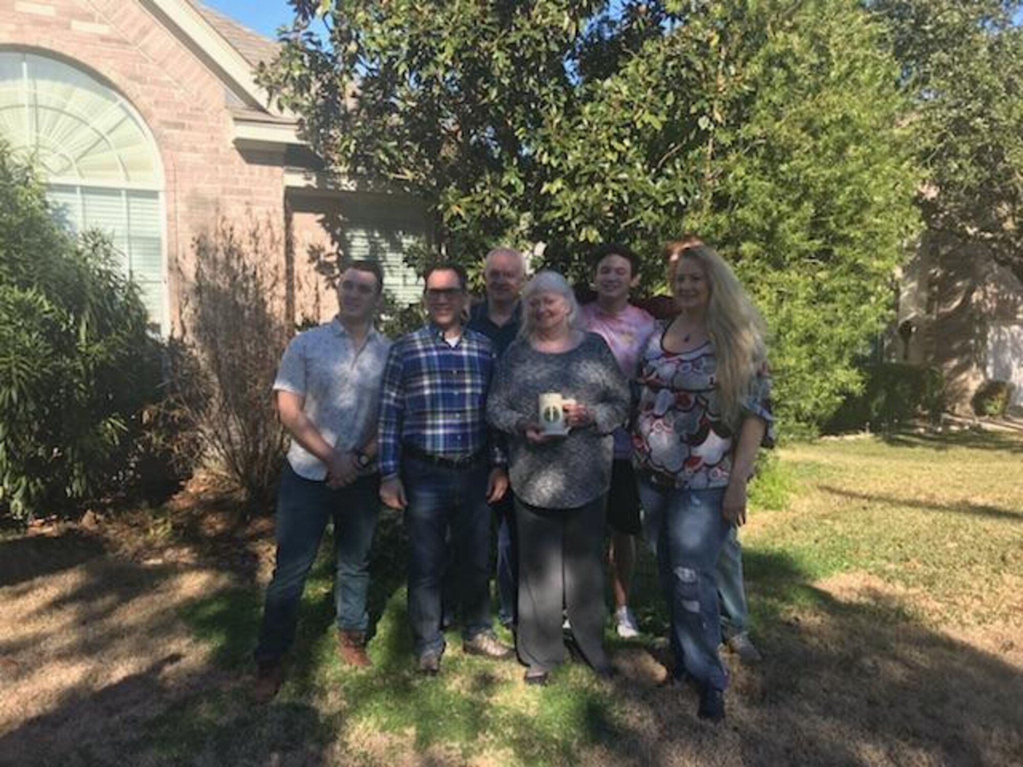 Retired Col. Martin Richard and his son Rylan pose with the family of Captain Paul L. Utz and his cherished stein, returned after being lost for five decades after his passing.