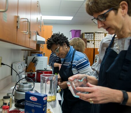Ellistene Curry, Defense Information Technology Contracting Organization contract specialist, and Deb Teague 932nd Airlift Wing Airman and Family Readiness director, assemble ingredients for a vegan macaroni and cheese recipe in the Airmen and Family Readiness Center at Scott Air Force Base, Ill., Jan. 18, 2019. The Foodie Friday class gives participants an opportunity to prepare, cook, and taste the meals taught during this hands on class.