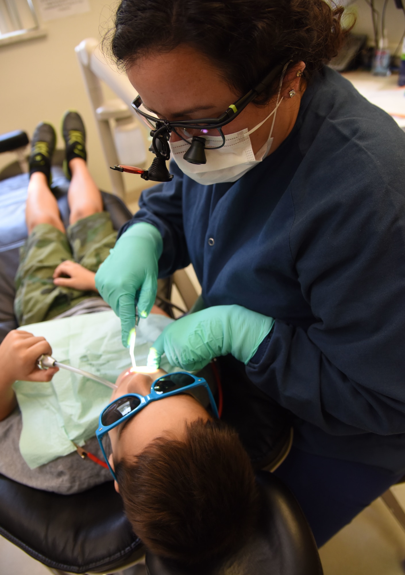 Kendra Cuevas, 81st Dental Squadron dental hygienist, provides a dental cleaning on Logan Lester, son of U.S. Navy Steelworker 2nd Class Ian Lester, a Seabee with Naval Mobile Construction Battalion 133, Naval Construction Battalion Center, Gulfport, Mississippi, during the 8th Annual Give Kids a Smile Day at the dental clinic Feb. 14, 2018, on Keesler Air Force Base, Mississippi. The event was held in recognition of National Children’s Dental Health Month and included free dental exams, radiographs and cleanings for children age two and older. (U.S. Air Force photo by Kemberly Groue)