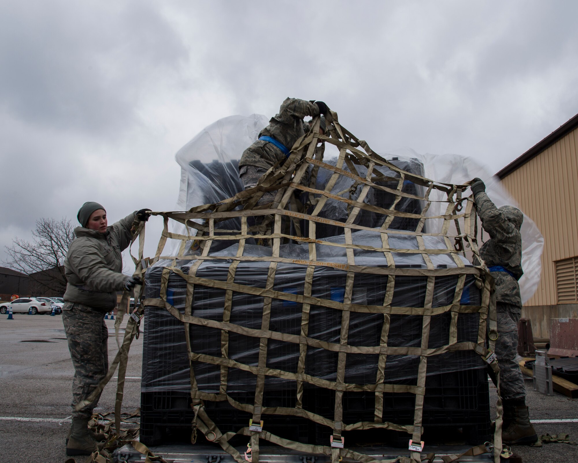 Airman 1st Class Emily Otten, 375th Logistics Readiness Squadron vehicle operator, along with Senior Airman Van Aerrus Sanchez, 375th LRS small air terminal representative, and Airman Brandon Rose, 375th LRS vehicle operator, secure crates of deployment bags to a pallet during a base-wide mobility exercise at Scott Air Force Base, Illinois, Jan. 23, 2019. During the exercise one of the responsibilities of the 375th LRS is assembling all the required equipment for the simulated deployment and prepping it to be shipped to the deployment location.