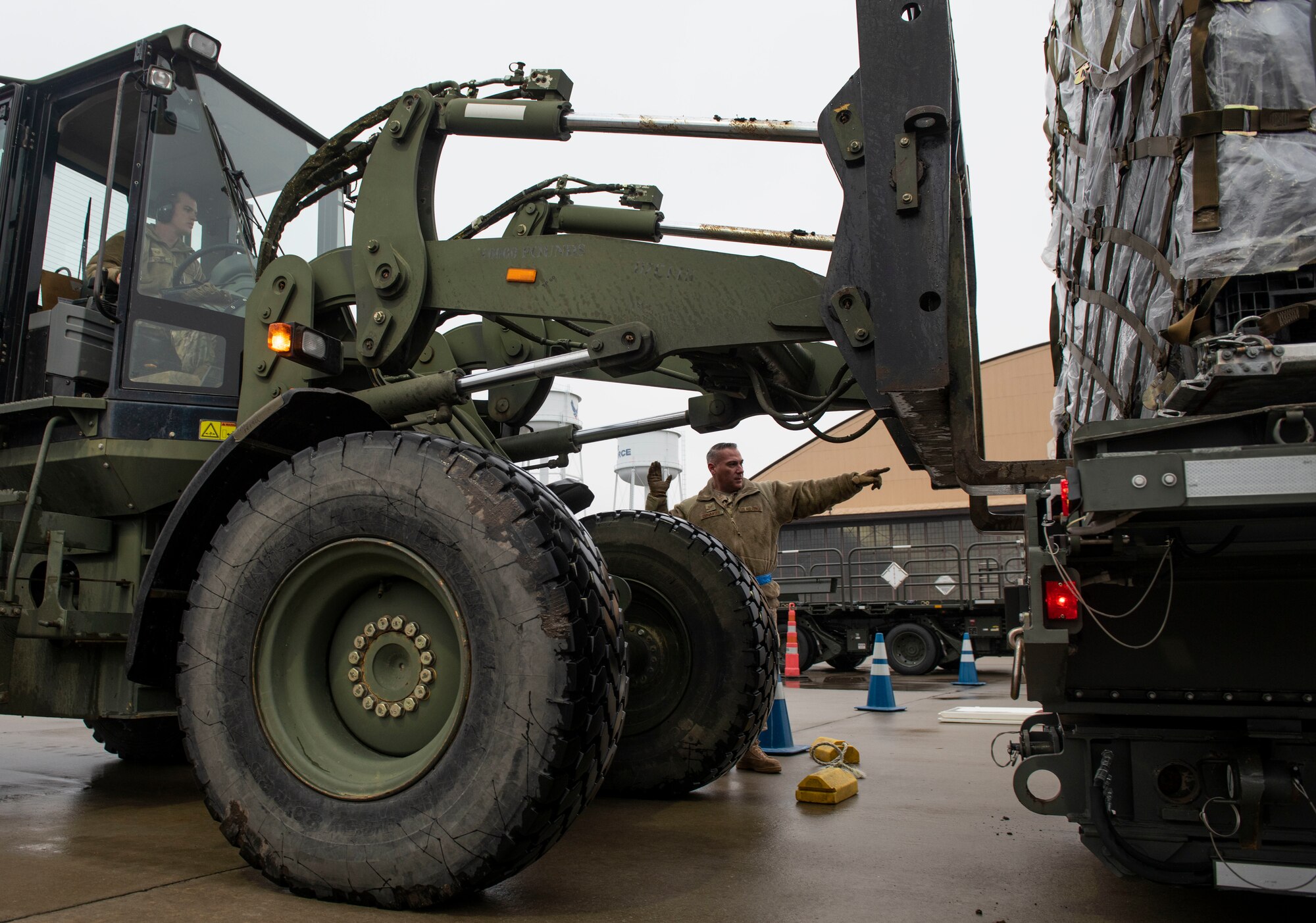 Tech. Sgt. Alfredo Cervantes, 375th Logistics Readiness Squadron NCO in charge of air transportation, guides Staff Sgt. Chance Sheek, 375th LRS ground transportation craftsman, as he operates a forklift carrying cargo during a mobility exercise, Jan. 23, 2019, at Scott Air Force Base, Illinois. Cervantes and Sheek were part of the Cargo Deployment Function, a team that ensures pallets are loaded onto an aircraft in a safe way that does not interfere with its center of gravity .