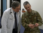 Maj. Gen. John J. DeGoes (right), 59th Medical Wing commander, coins Dr. Kenneth McGill (left), family care practitioner, during his visit to the Gateway Bulverde Clinic in San Antonio Jan. 25. DeGoes visited Gateway Bulverde Clinic to recognize the team for outstanding patient care.