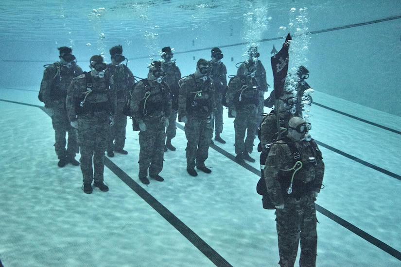 U.S. Army Soldiers from the 74th Engineer Dive Detachment, 92nd Eng. Battalion, stand at attention underwater during a change of command ceremony at the Anderson Field House pool at Joint Base Langley-Eustis, Virginia, Jan. 25, 2019.