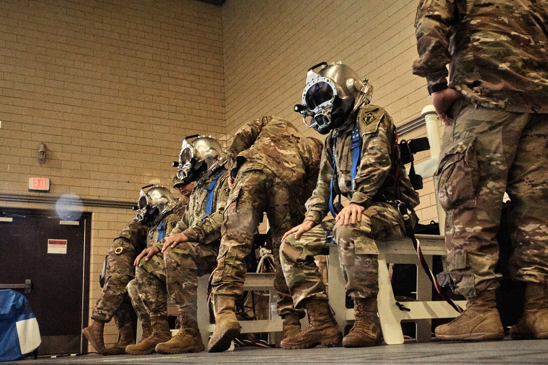 (Right) U.S. Army Capt. Barrett LeHardy, 74th Engineer Dive Detachment, 92nd Eng. Battalion outgoing commander, (middle) Lt. Col. Perry Stiemke, 92nd Eng. Btn. commander, and (left) Capt. Maxwell McDonnell, 74th Eng. Dive Det., 92nd Eng. Btn., don their diving gear during a change of command ceremony at the Anderson Field House pool at Joint Base Langley-Eustis, Virginia, Jan. 25, 2019.