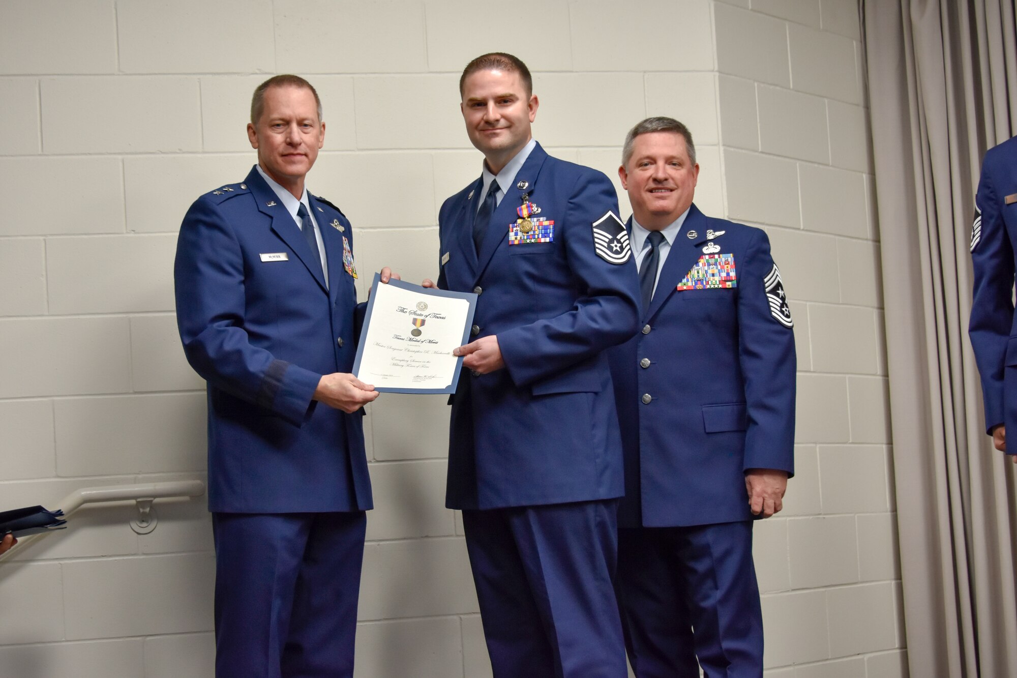 Master Sgt. Christopher Macharelli, 136th Maintenance Group quality assurance chief inspector, receives certificate from Maj. Gen. David McMinn, commander of the Texas Air National Guard, and Chief Master Sgt. Christopher Castle, command chief of the TANG, during the Outstanding Airman of the Year award ceremony January 13, 2019 at Camp Mabry in Austin, Texas. Macharelli was one of five Airmen chosen to compete from the 136th Airlift Wing. (U.S. Air National Guard photo by Tech. Sgt. Katy Whitt)