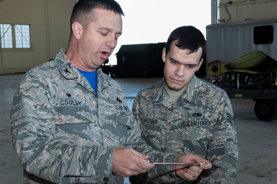 U.S. Air Force Reserve Col. Casey Cooley, 307th Maintenance Group commander, presents the “Knuckle Buster” award to Senior Airman Tyler Levesque on Jan. 25, 2019, Barksdale Air Force Base, Louisiana. Levesque is assigned to the 2nd Maintenance Squadron and received the award for discovering that two control cables (the Lateral Control cable and the Drag Chute cable) on a B-52H Stratofortress were improperly routed. His perserverance in ensuring the cables were correctly configured displayed his professionalism and dedication. (U.S. Air Force photo by Greg Steele)