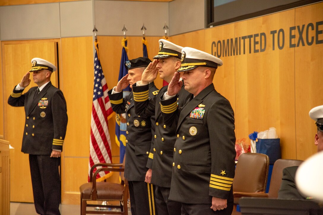 Defense Intelligence Agency Director Lt. Gen. Robert P. Ashley,. Jr., second from left, outgoing Defense Intelligence Agency Navy Element Commander Capt. Joshua C. Himes, second from right, and incoming Navy Element commander, Capt. Peter N. Shepard, right, salute during a change of command ceremony, Jan. 30, at the DIA headquarters on Joint Base Anacostia-Bolling.