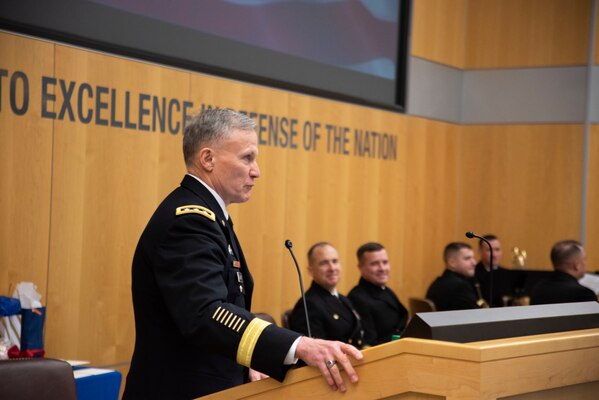 Defense Intelligence Agency Director Lt. Gen. Robert P. Ashley,. Jr., delivers remarks as outgoing DIA Navy Element Commander Capt. Joshua C. Himes, seated left, and incoming Navy Element commander, Capt. Peter N. Shepard, seated right, listen during a change of command ceremony, Jan. 30, at the DIA headquarters on Joint Base Anacostia-Bolling.