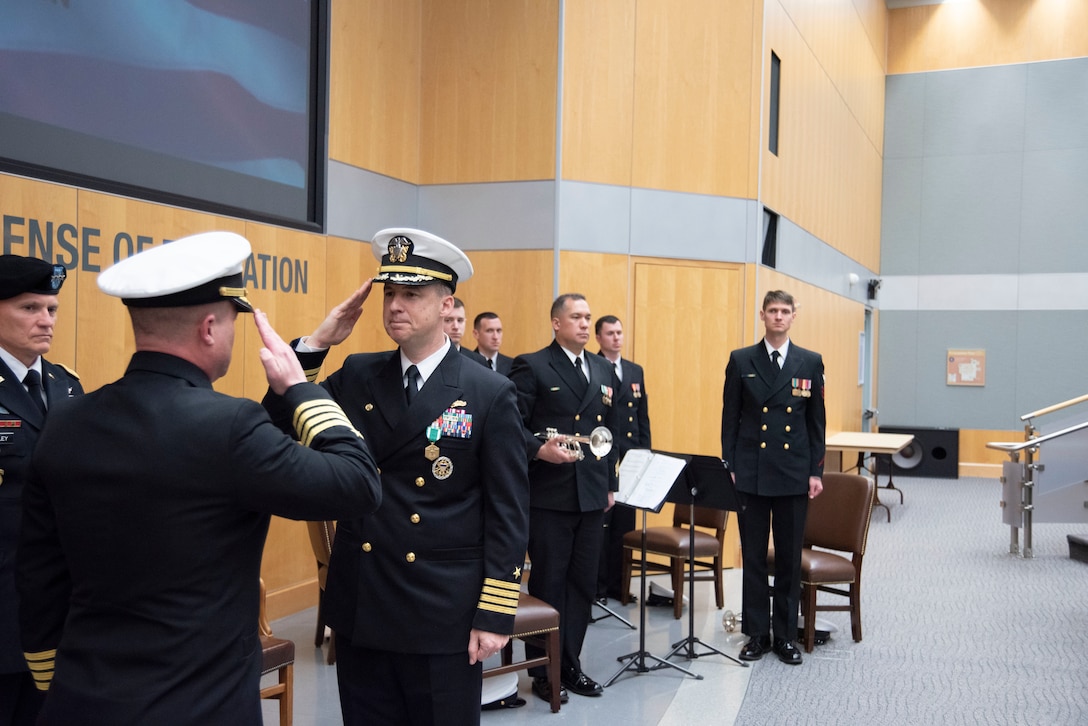 Capt. Joshua C. Himes, right, relinquishes command of the Defense Intelligence Agency Navy Element to Capt. Peter N. Shepard, left, during a change of command ceremony, Jan. 30, at the DIA headquarters on Joint Base Anacostia-Bolling.