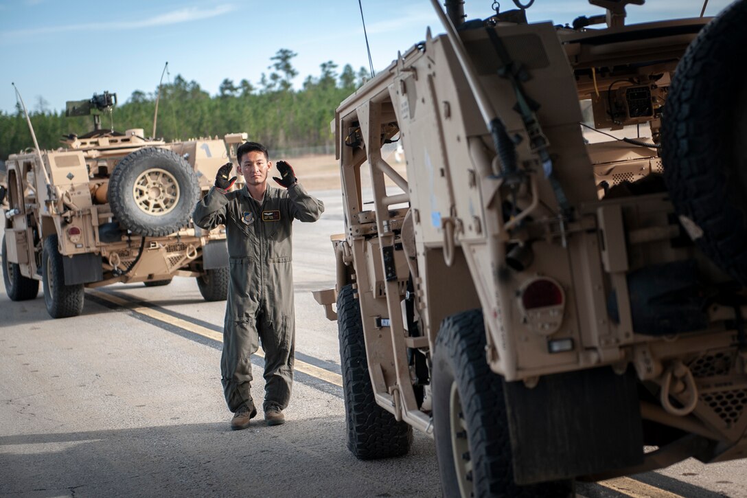 Staff Sgt. Sean Chang, 204th Airlift Squadron loadmaster, guides a U.S. Army High Mobility Multipurpose Wheeled Vehicle onto a C-17 Globemaster III