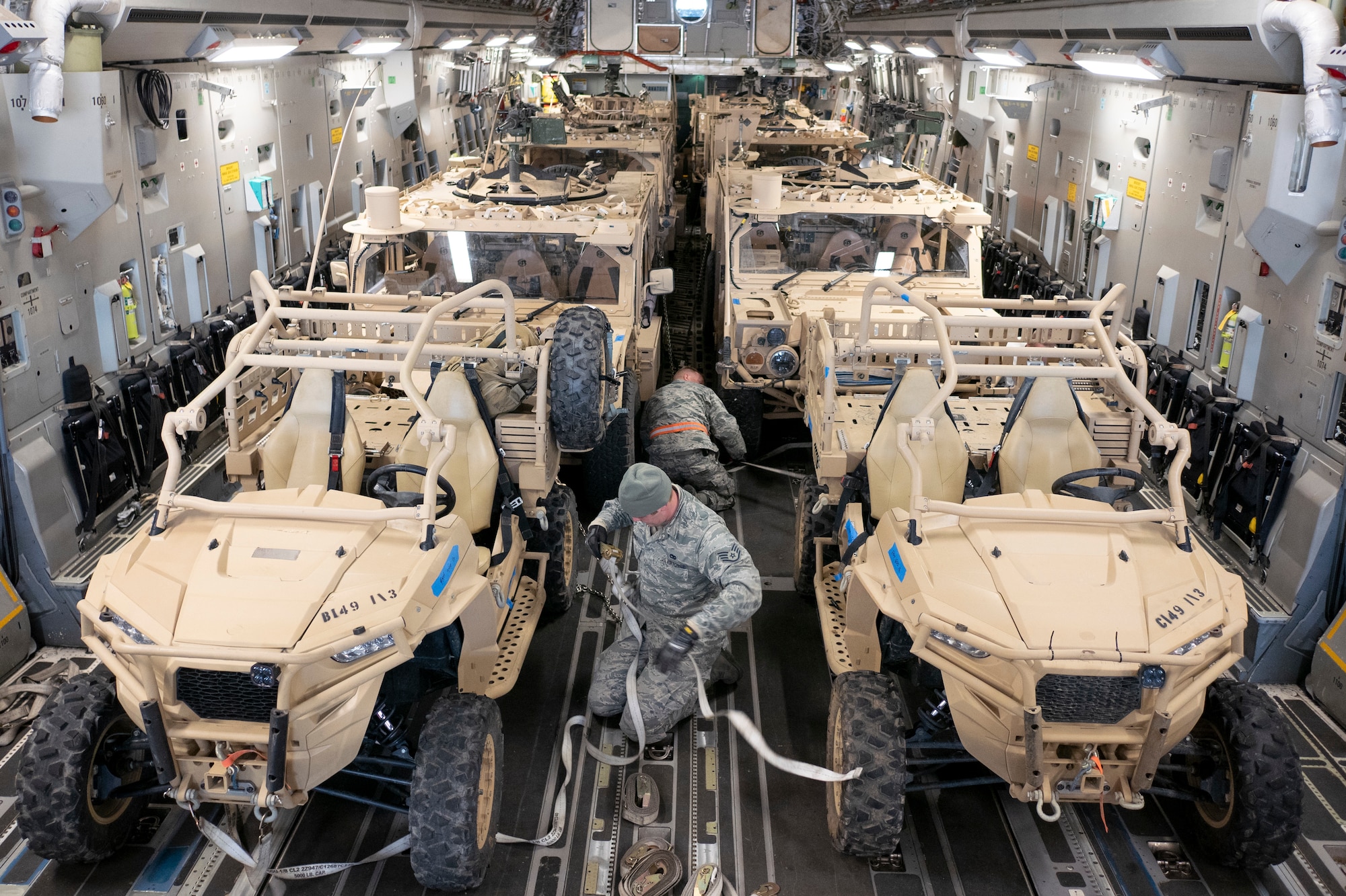 Members of the 164th Logistics Readiness Squadron secure U.S. Army vehicles onto a Hawaii Air National Guard C-17 Globemaster III
