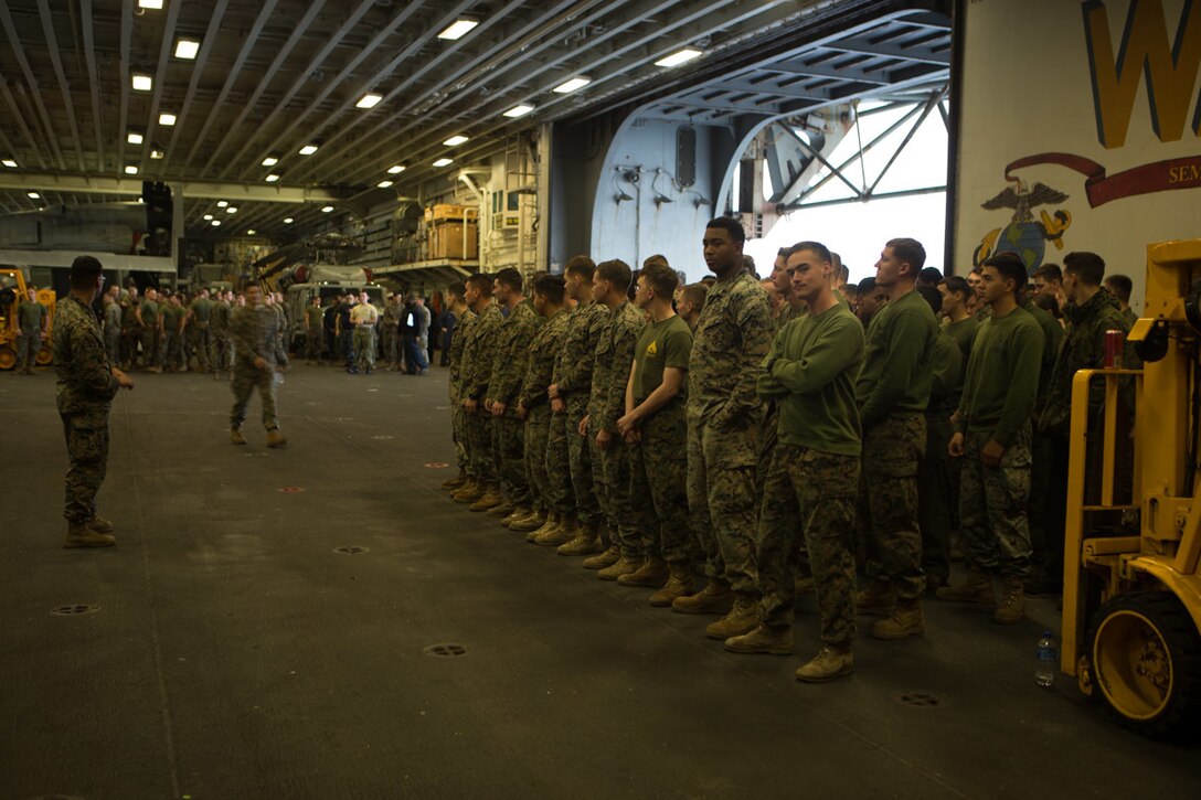 Marines with the 31st Marine Expeditionary Unit and Sailors with the amphibious assault ship USS Wasp (LHD 1) stand in formation during replenishment at sea, Jan. 20, 2019. During the RAS, the Marines and Sailors unloaded, sorted and stored 107 pallets of frozen foods, dry stores, and fresh fruits and vegetables. The 31st MEU, the Marine Corps’ only continuously forward-deployed MEU partnering with the Wasp ARG, provides a flexible and lethal force ready to perform a wide range of military operations as the premier crisis response force in the Indo-Pacific region. (Official Marine Corps video by Cpl. Luis Velez/ Released)