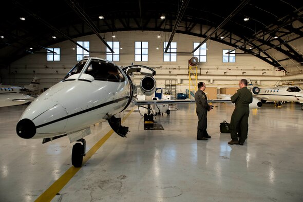 458th Airlift Squadron pilots, Maj, Taylor Todd and Capt. Nicholas Parrish, discuss preflight procedures prior to a training flight at Scott Air Force Base, Illinois on Dec. 17, 2018. In 2019, the 458th AS celebrates 35 years of C-21 operations at Scott AFB. One by one, C-21s are being sent to Wichita, Kansas, to receive new avionics and communications suites that will expand the aircraft’s reach, effectiveness, and capability. The upgrades come in time to meet FAA’s 2020 equipment mandate to keep increasingly congested airspace safe.