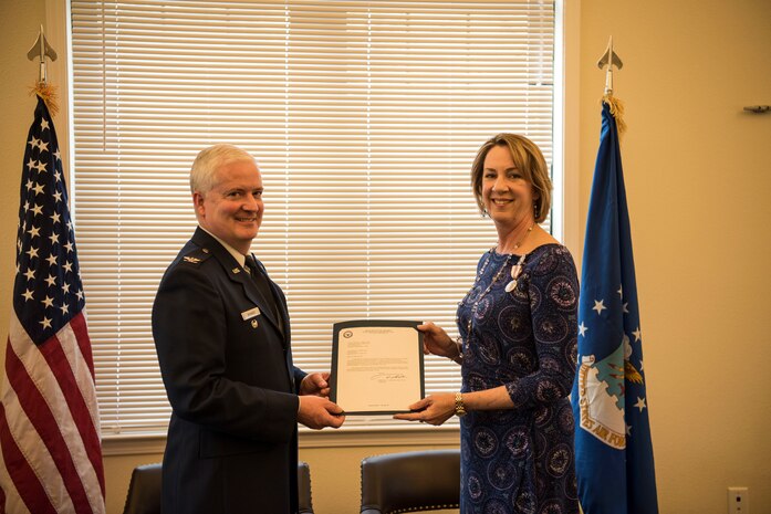 Kathy Edenborough, 628th Contracting Squadron director of business operations and 628th Air Base Wing small business specialist, receives her retirement certificate from Col. Dale Skinner, Air Force Life Cycle Management Center deputy director of contracting, during her retirement ceremony Jan. 30, 2019, at the Hunt Community Center on Joint Base Charleston, S.C.