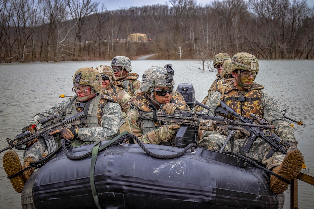 Soldiers set off down a river in a rubber boat.