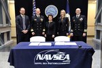 WASHINGTON (Jan. 31, 2019) -- Ryan Daniels, Naval Sea Systems Command contracting officer; Rear Adm. Brian Antonio, program executive officer for Aircraft Carriers; Jennifer Boykin, executive vice president, Huntington Ingalls Industries - Newport News Shipbuilding (HII-NNS); Christie Thomas, HII-NNS and Capt. Philip Malone, program manager, PMS 379, gather after the award of a contract action to procure both the future USS Enterprise (CVN 80) and unnamed CVN 81 in a ceremony at the Washington Navy Yard. The multi-carrier contracting strategy, used successfully for Nimitz-class aircraft carriers in the 1980s, keeps the Navy on the path to a bigger, more lethal fleet while maximizing industry's efficiency and leveraging important lessons learned so far in building the next generation of nuclear-powered aircraft carriers, the Gerald R. Ford class. (U.S. Navy Photo by Laura Lakeway/Released