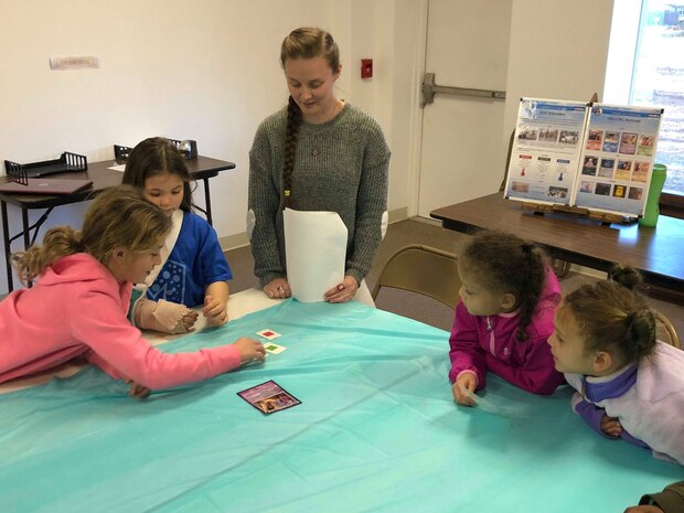 Naval Surface Warfare Center Panama City Division Scientist Myranda Chapman (center) observes students participating in a mock wargame between princesses and villains during a Girls Inc. science, technology, engineering, and mathematics outreach event Jan. 30, 2019. U.S. Navy photo by Katherine Mapp