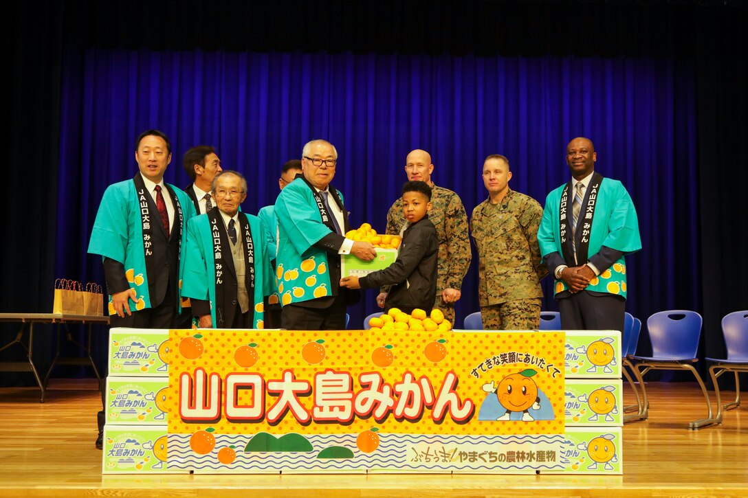 Visitors from Suo-Oshima present air station students with mikans