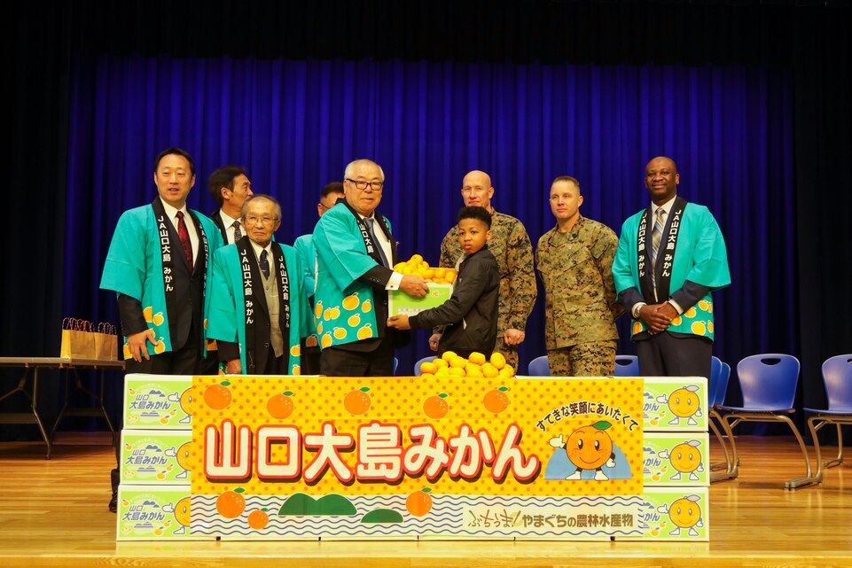 Visitors from Suo-Oshima present air station students with mikans