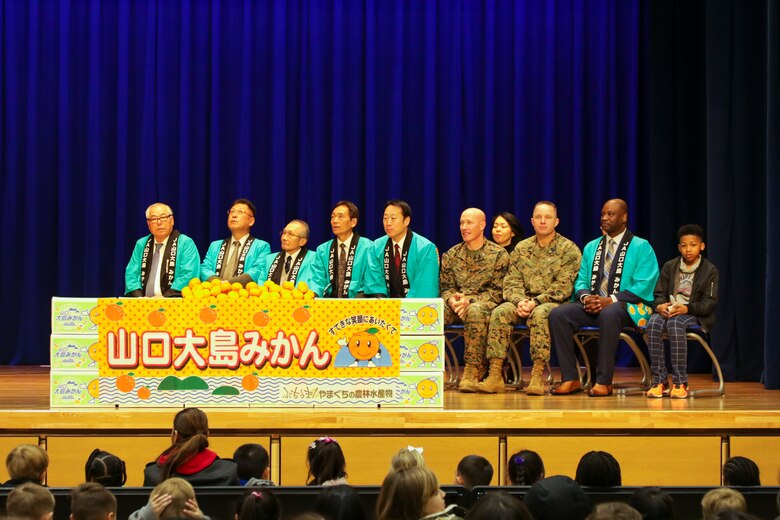 Visitors from Suo-Oshima present air station students with mikans