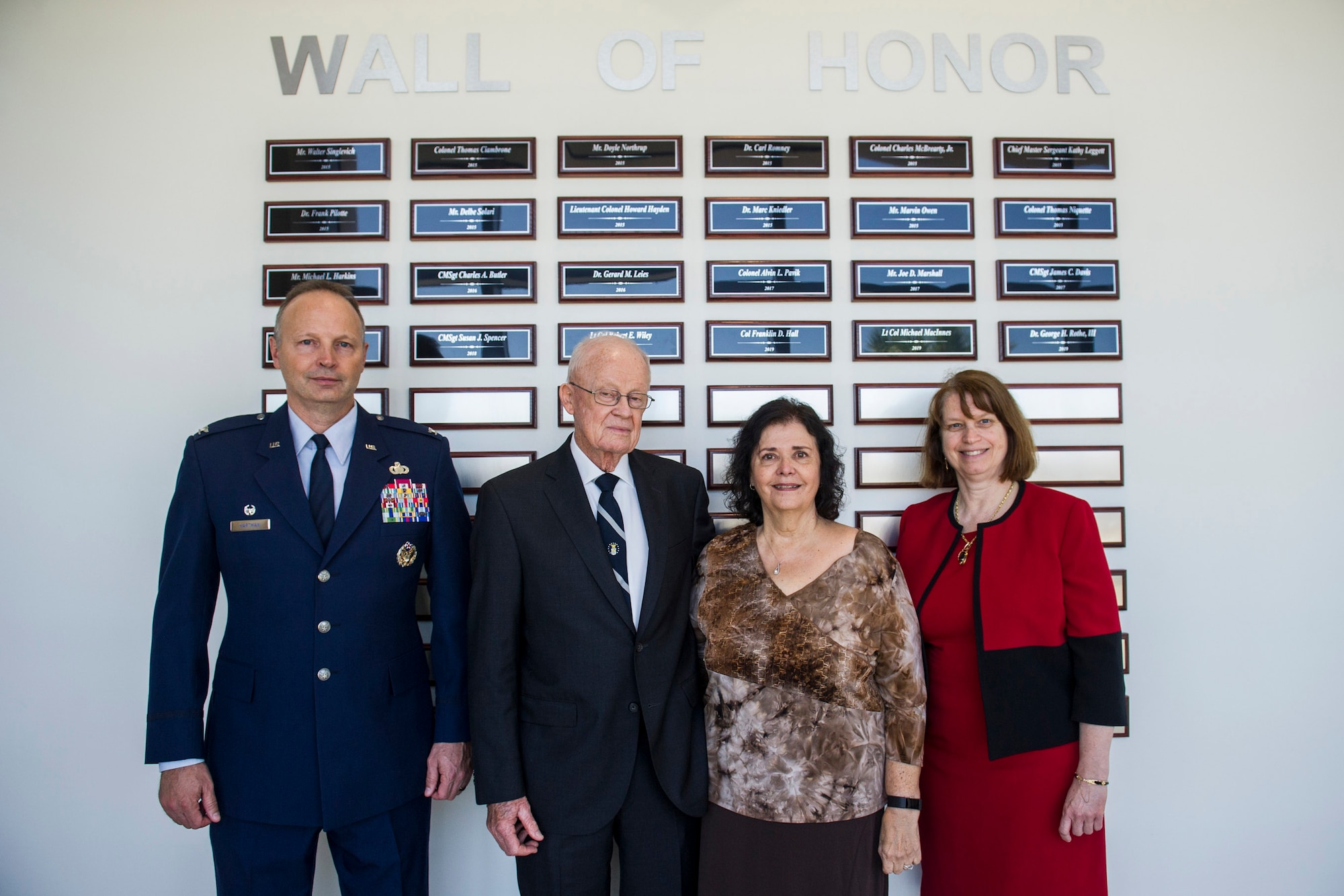 Inductees and honored guests pose for a photo in front of the Wall of Honor at the Air Force Technical Applications Center at Patrick AFB, Fla., April 30, 2019.  Pictured from right to left:  Col. Chad Hartman, AFTAC commander; Col. (ret.) Franklin D. Hall, inductee; Donna Jean, wife of inductee Dr. George H. Rothe III; and Doris Bruner, an AFTAC technical advisor who accepted the award for Lt. Col. (ret) Michael MacInnes.  (U.S. Air Force photo by Jared Trimarchi)