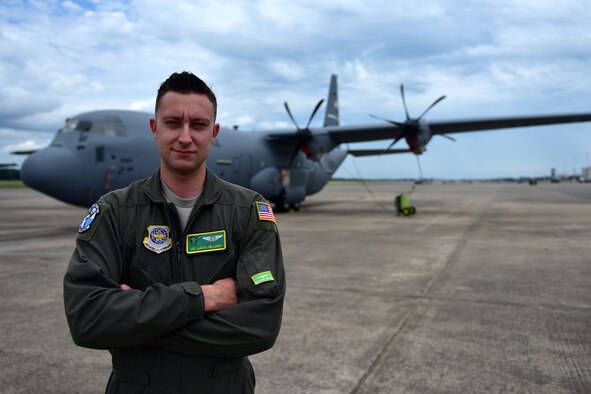 A man wearing a flight suit stands in front of a C-130J.
