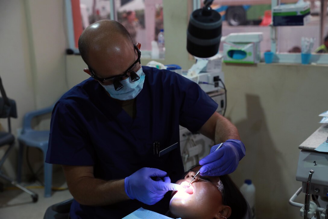 A dentist  performs a dental exam.