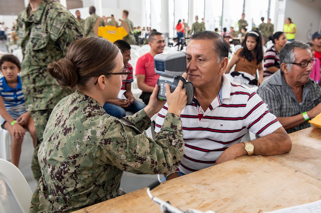 A doctor gives an eye exam.