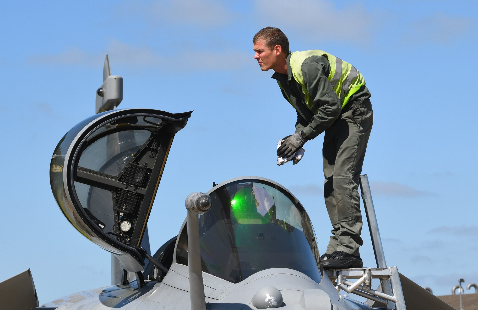 A French Air Force maintainer cleans the windscreen of a Rafale during exercise Point Blank 19-2 at Royal Air Force Lakenheath, England, June 17, 2019. Point Blank is a trilateral exercise focused on fourth and fifth-generation aircraft integration. (U.S. Air Force photo by Staff Sgt. Alex Fox Echols III/Released)