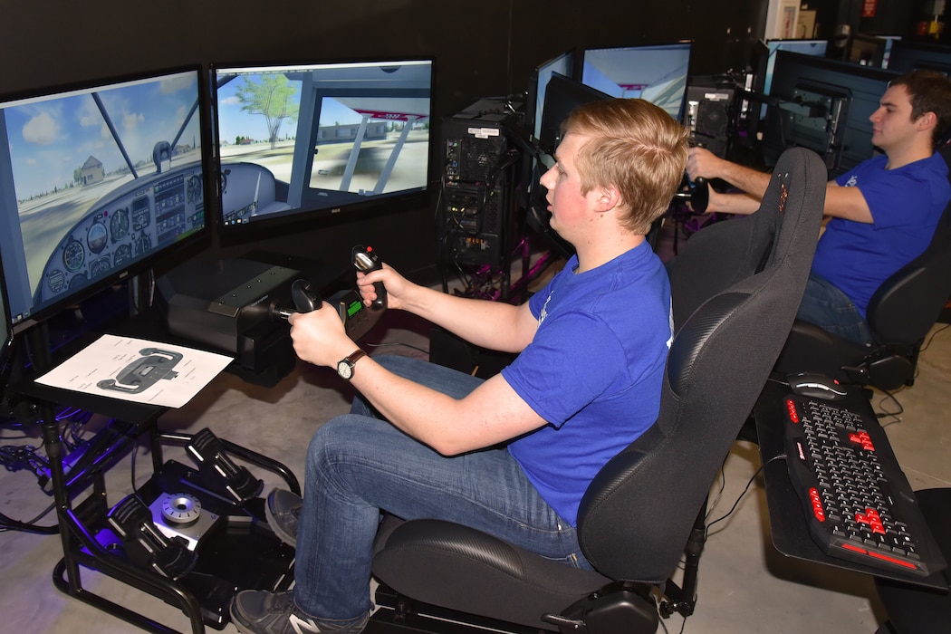 Picture of two young men flying a flight simulator.