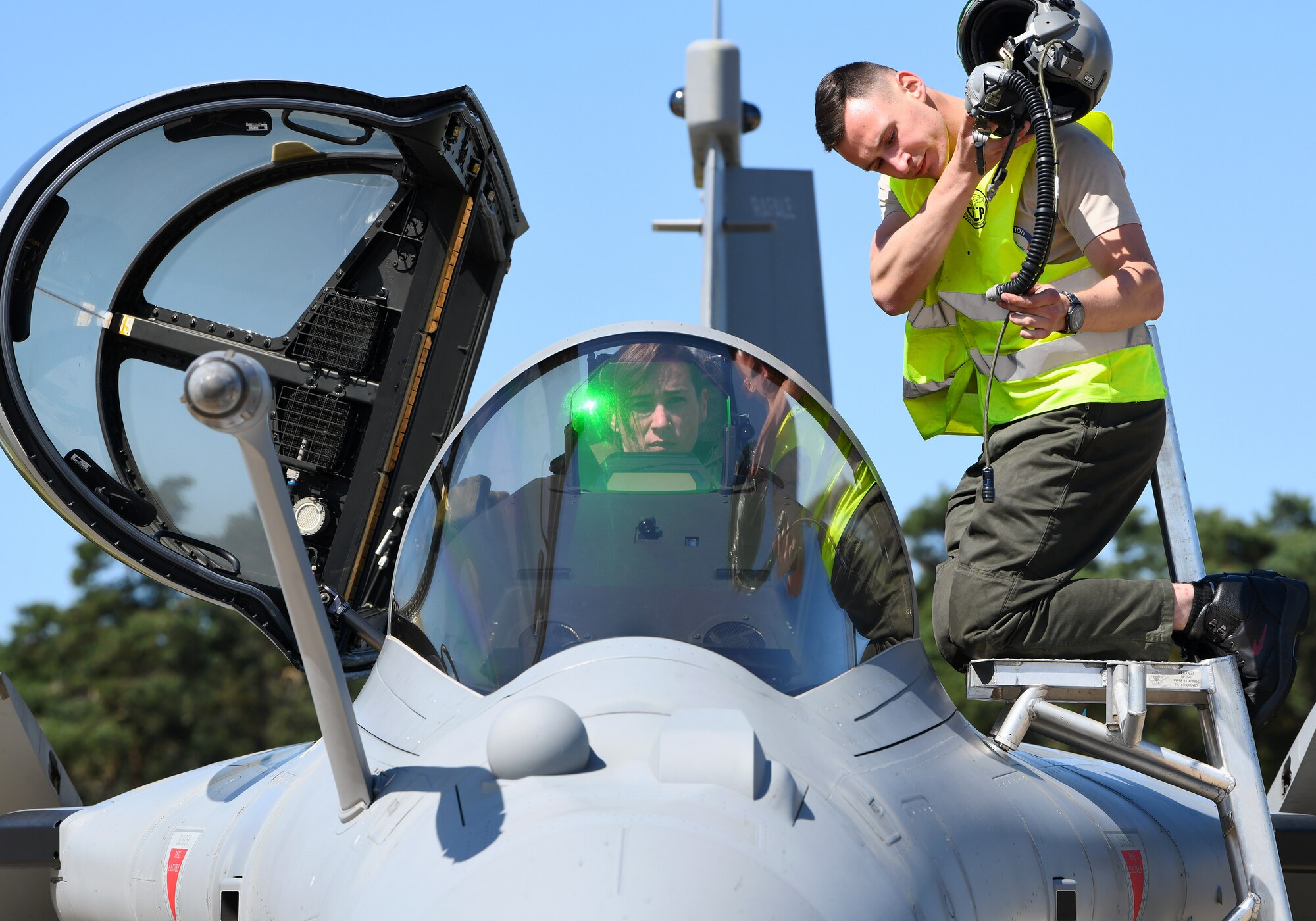 A French Air Force maintainer readies a pilot’s helmet during exercise Point Blank 19-2 at Royal Air Force Lakenheath, England, June 17, 2019. Routine multinational training exercises like Point Blank increase participating air force’s ability to integrate with other allied nations. (U.S. Air Force photo by Staff Sgt. Alex Fox Echols III/Released)