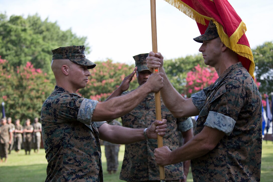 U.S. Marine Corps Col. Thomas H. Campbell III, right, the outgoing commanding officer of Headquarters and Service Battalion, U.S. Marine Corps Forces Command, passes the colors to Col. Mark R. Reid, the incoming battalion commanding officer, during a change of command ceremony at Naval Support Activity Hampton Roads, Virginia, June 27, 2019. The change of command is a time-honored tradition where the responsibilities and authority of command are ceremoniously passed from one commander to the next. (U.S. Marine Corps photo by Sgt. Jessika Braden/ Released)