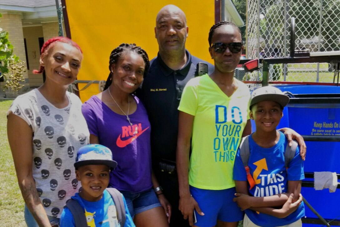 U.S. Air Force Tech. Sgt. Neosha Benson, second from left, stands with children and other volunteers during a charity drive to collect school supplies for school children in Monroe, Louisiana, (date).  The drive was one of several different charitable events Benson helped make possible. Benson is the unit training manager for the 307th Force Support Squadron. (courtesy photo)