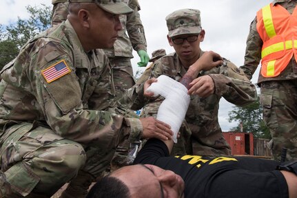 U.S. Army Spc. Jonathan Lee, Joint Task Force – Bravo Medical Element, provides on-scene medical treatment to a simulated burn victim during a joint training exercise June 26, 2019, at Soto Cano Air Base, Honduras. Members from Joint Task Force – Bravo’s Medical Element, 612th Air Base Squadron firefighters and 480th Military Police Company worked together to accomplish goals during the training event. The event involved the firefighters entering a smoke-filled building to recover burn casualties while the Medical Element performed triage at the scene. The 480TH MPC members provided a cordon of the area and kept rioting personnel from entering the scene. (U.S. Air Force photo by Staff Sgt. Eric Summers Jr.)