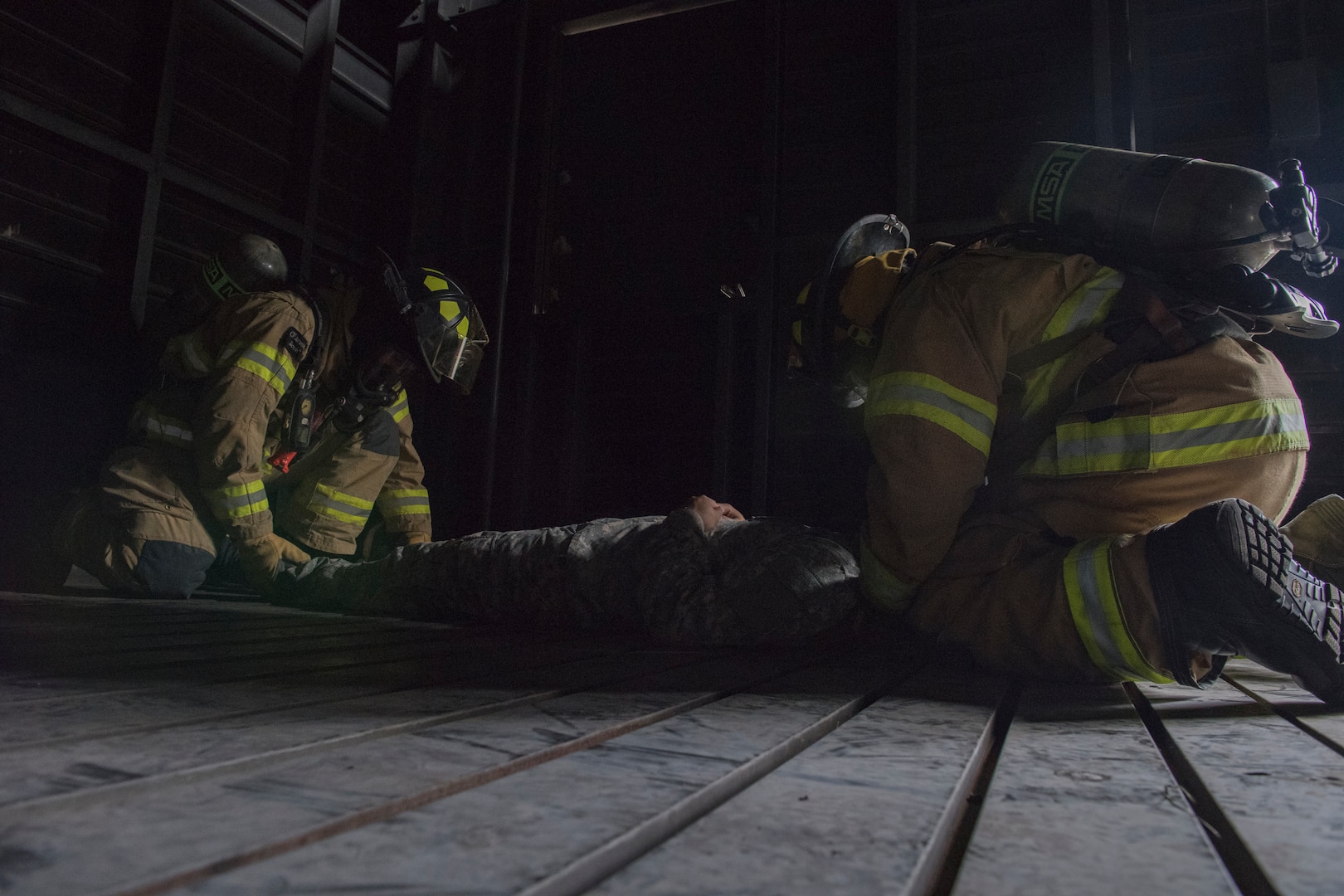 U.S. Air Force Firefighters from the 612th Air Base Squadron carry a patient from a smoke-filled building during a joint training exercise June 26, 2019, at Soto Cano Air Base, Honduras. Members from Joint Task Force – Bravo’s Medical Element, 612th Air Base Squadron firefighters and 480th Military Police Company worked together to accomplish goals during the training event. The event involved the firefighters entering a smoke-filled building to recover burn casualties while the Medical Element performed triage at the scene. The 480TH MPC members provided a cordon of the area and kept rioting personnel from entering the scene. (U.S. Air Force photo by Staff Sgt. Eric Summers Jr.)