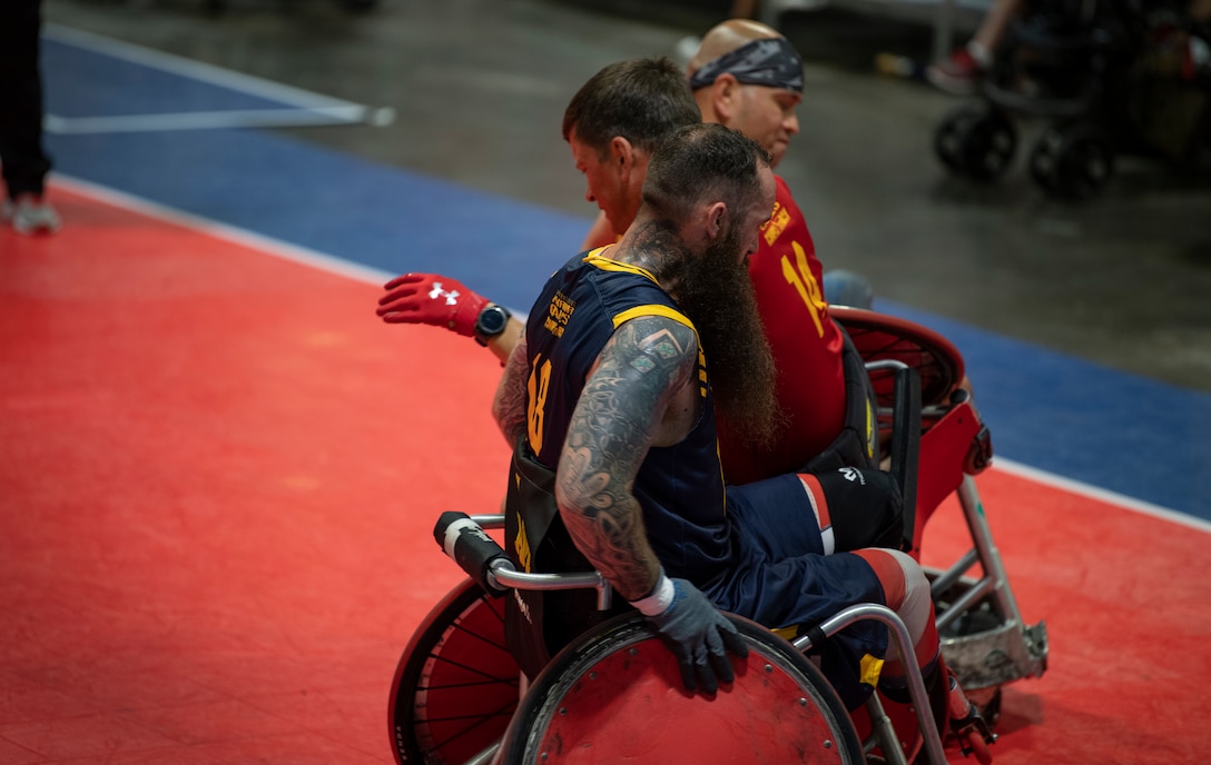 U.S. Navy team members make a Marine Corps sandwich with Staff Sgt. Jason Pritchett during the DoD Warrior Games Wheelchair Rugby competition in Tampa, Florida, June 27, 2019. The DoD Warrior Games is an adaptive sports competition for wounded, ill and injured service members and veterans. The 2019 Warrior Games consist of 13 Paralympic-style sports, and more than 300 athletes representing the U.S. Marine Corps, Army, Navy, Air Force, Special Operations Command, and five international teams.