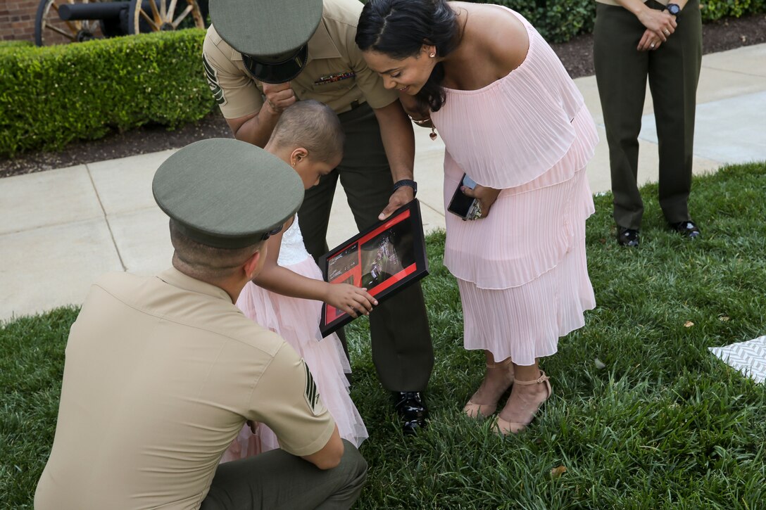 Analia Naylin Pages receives a plaque from the Marines of Marine Barracks Washington thanking her for attending 2nd phase parade practice at Marine Barracks Washington, D.C., June 28, 2019. Analia Naylin Pages, the daughter of Master Sgt. Edward Pages III and retired Gunnery Sgt. Ana Liz Perez has B-Cell Acute Lymphoblastic Leukemia and served as our guest of honor for the parade practice.