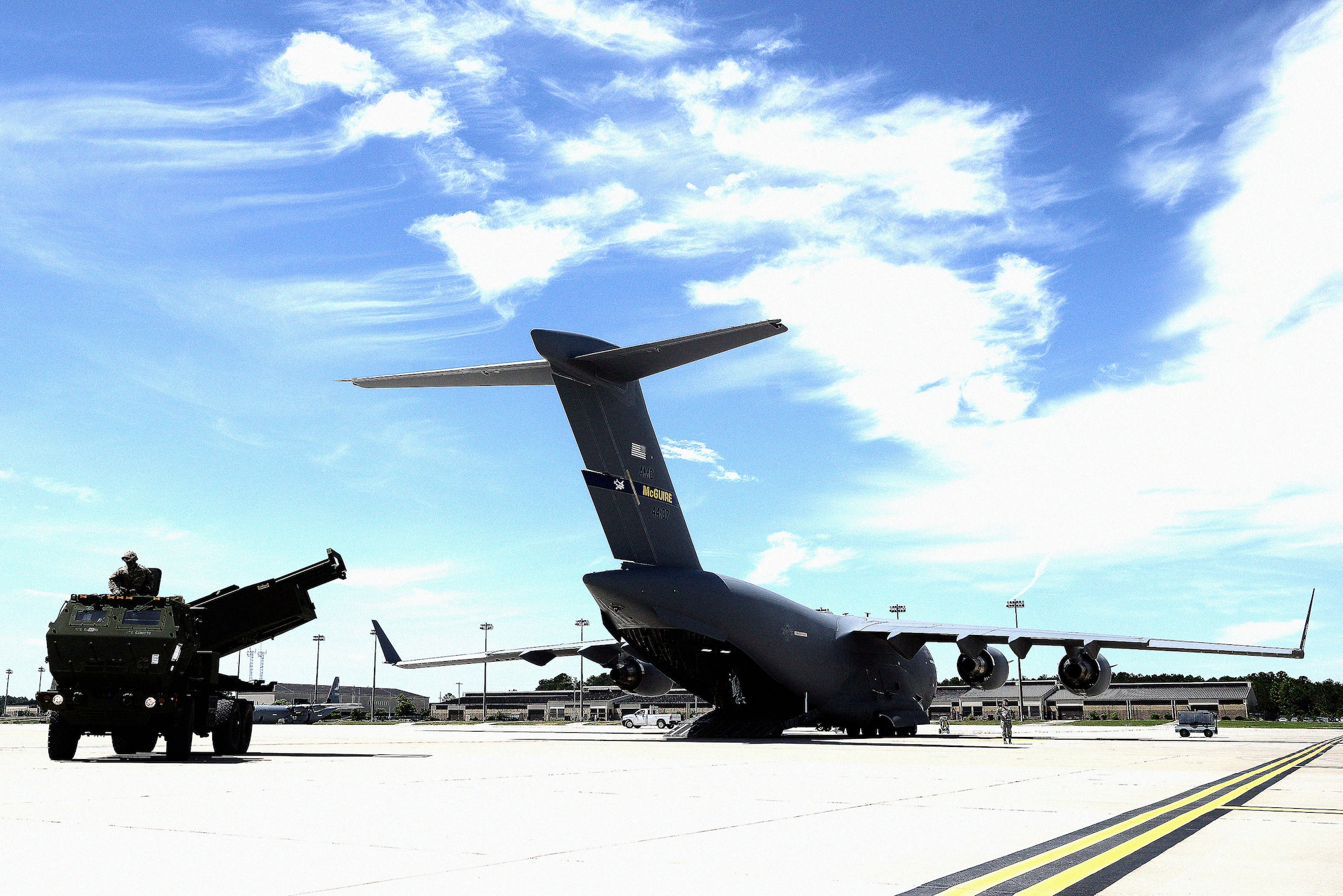 A U.S. Army Soldier from the 3rd Battalion, 321st Field Artillery Regiment at Ft. Bragg, North Carolina, positions a High Mobility Artillery Rocket System launcher after exiting a U.S. Air Force C-17 Globemaster III from the 305th Air Mobility Wing at Joint Base McGuire-Dix-Lakehurst, New Jersey, during a joint-service HIMARS Rapid Infiltration exercise at Pope Army Airfield, North Carolina, June 25, 2019.  The combination of rapid global mobility and agile ground artillery produces precision long-range mission execution.