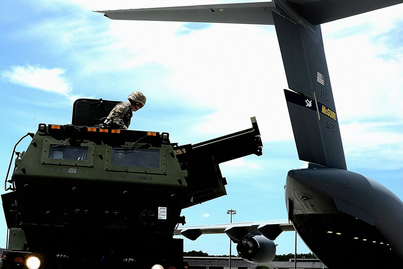 A U.S. Army Soldier from the 3rd Battalion, 321st Field Artillery Regiment at Ft. Bragg, North Carolina, positions a High Mobility Artillery Rocket System launcher after exiting a U.S. Air Force C-17 Globemaster III from the 305th Air Mobility Wing at Joint Base McGuire-Dix-Lakehurst, New Jersey, during a joint-service HIMARS Rapid Infiltration exercise at Pope Army Airfield, North Carolina, June 25, 2019. The combination of rapid global mobility and agile ground artillery produces precision long-range mission execution. (U.S. Air Force photo by Tech. Sgt. Austin Knox)