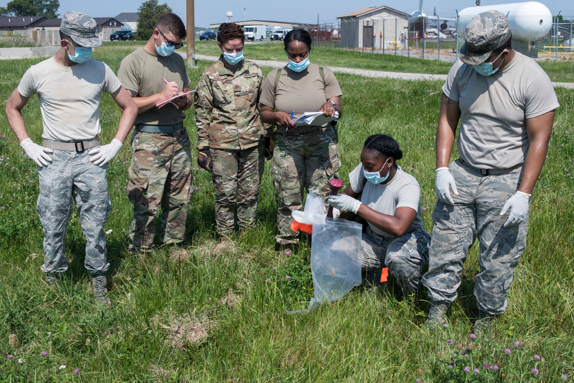 Airmen from the 436th Force Support Squadron conduct a search during a search-and-recovery exercise June 28, 2019, at Dover Air Force Base, Del. After a team member would locate an item, the team would stop, tag, photograph and log the item. (U.S. Air Force photo by Senior Airman Christopher Quail)
