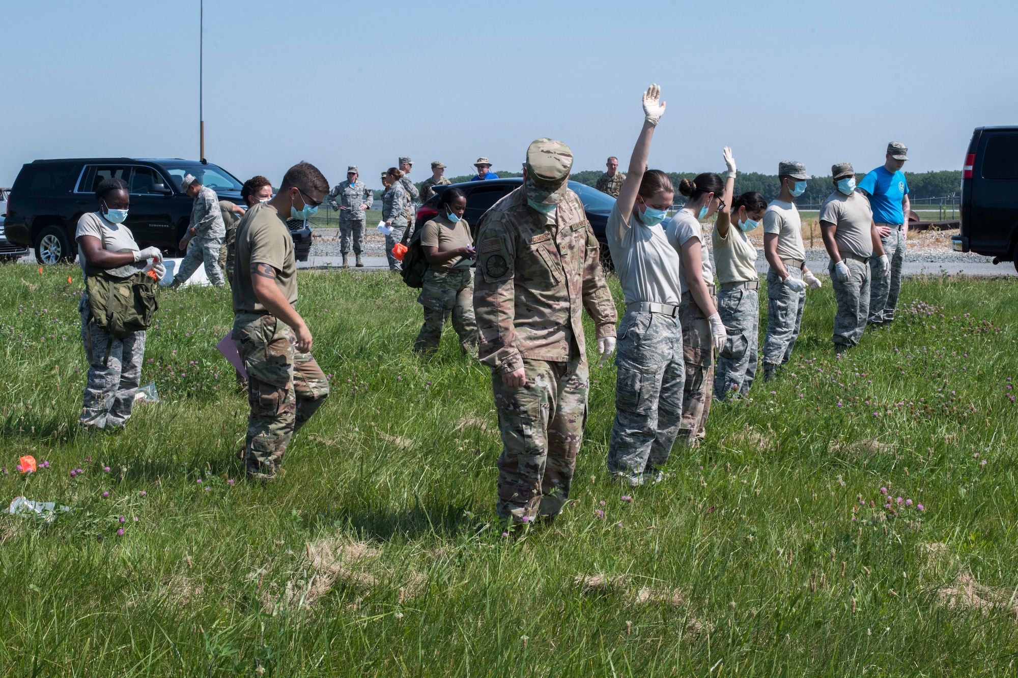 Airmen from the 436th Force Support Squadron conduct a search during a search-and-recovery exercise June 28, 2019, at Dover Air Force Base, Del. The team swept the field in a horizontal line – arm’s length apart, step by step – to ensure nothing was missed. A team member would raise a hand when an item was located. (U.S. Air Force photo by Senior Airman Christopher Quail)