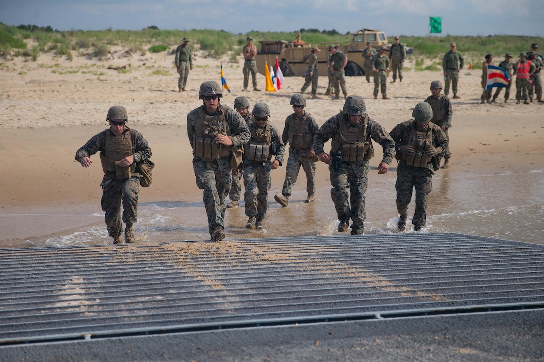 U.S Marines with 2nd Transportation Support Battalion, Combat Logistics Regiment 2, 2nd Marine Logistics Group, run aboard a Navy improved navy lighterage system during exercise Resolute Sun at Fort Story, Virginia, June 17, 2019. Marines participated in the exercise to increase combat operational readiness in amphibious and prepositioning operations while conducting joint training with U.S. Army during a joint logistics over the shore scenario.