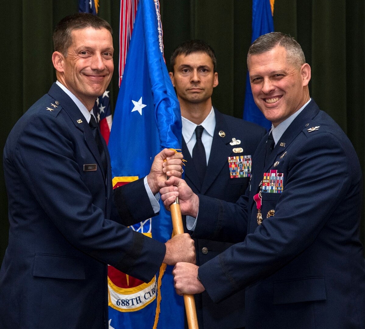 Col. Eric DeLange (right) relinquishes command of the 688th Cyberspace Wing to Maj. Gen. Robert Skinner, 24th Air Force commander, during the wing’s change of command ceremony at Joint Base San Antonio-Lackland June 25. Col. Steven Anderson took command of the 688th CW during the ceremony.